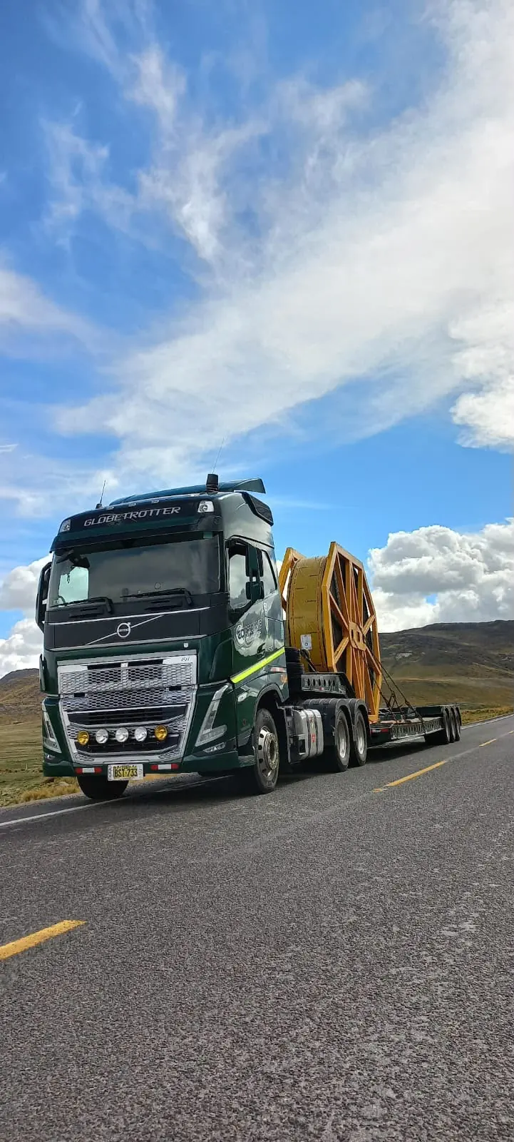 Tracto Volvo de CORTRANS con carrete industrial sobre plataforma en carretera
