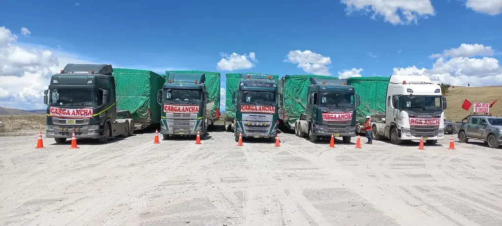 Cinco tractos de CORTRANS alineados con carga entoldada y señalización de carga ancha