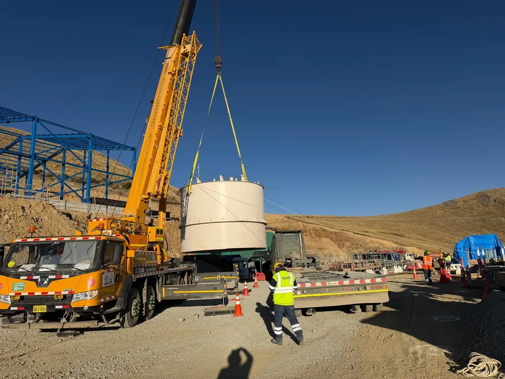 Grúa izando un tanque desde la plataforma en una obra
