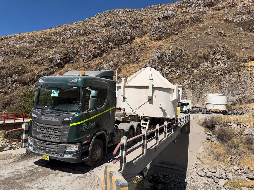 Tracto Scania cruzando un puente con una tolva sobredimensionada
