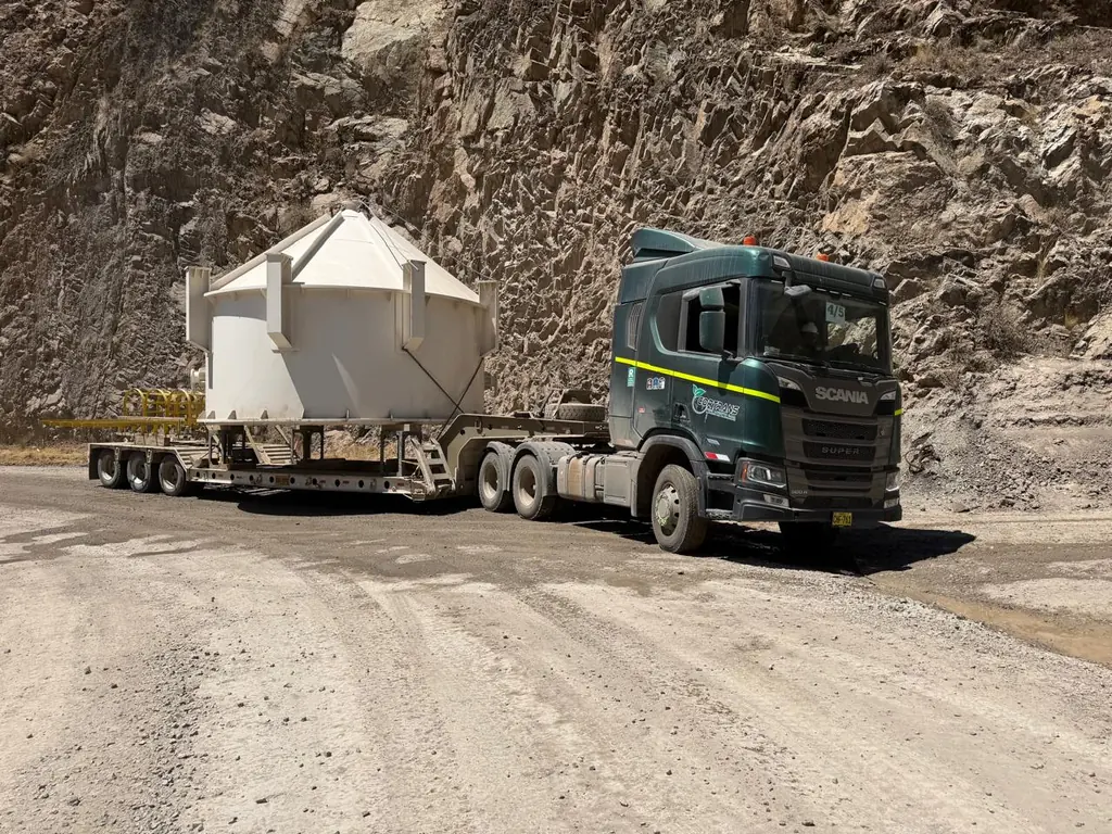 Tracto Scania con cama cuna trasladando una tolva en cantera